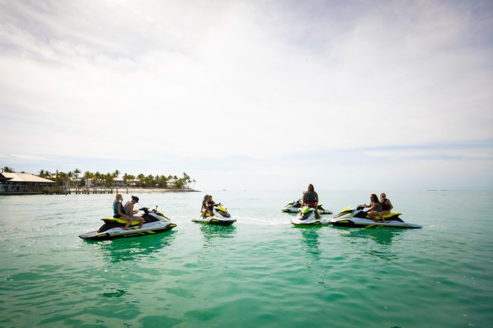 a group of people riding on the back of a boat in the water